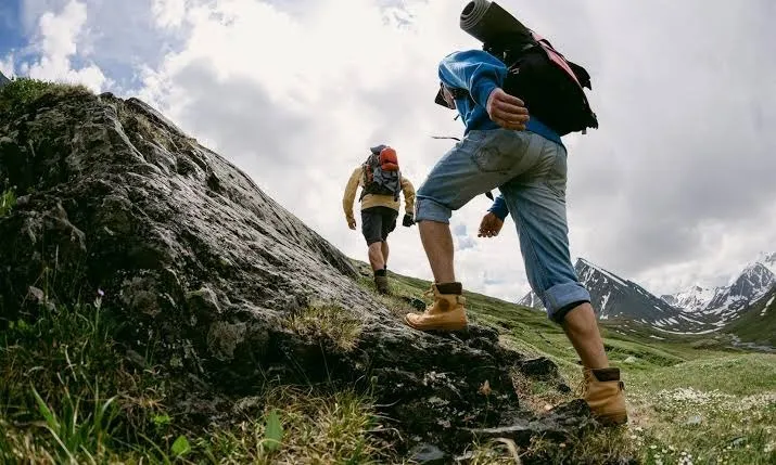 Hikers on mountain trail at sunrise with layered hiking apparel