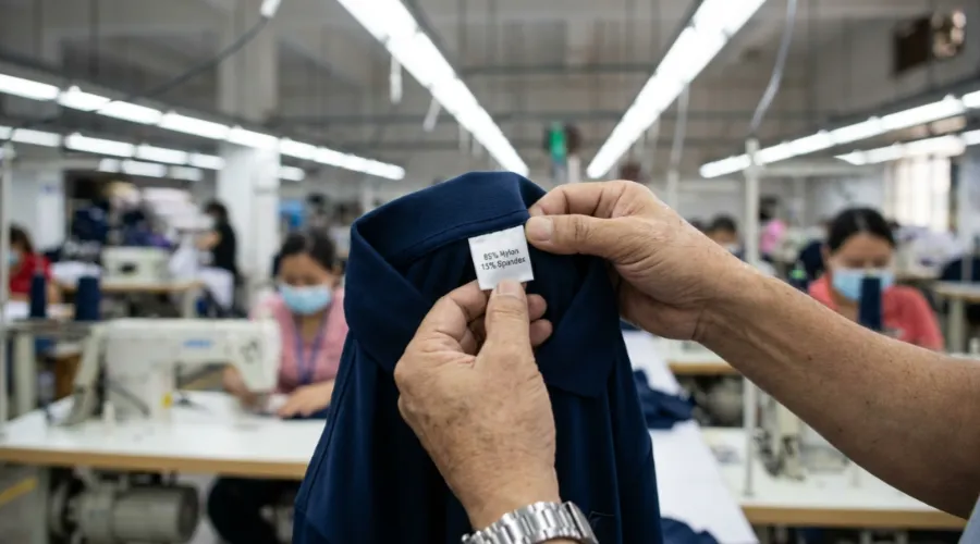 Manager Chen inspecting FTC compliant care labels in the factory.
