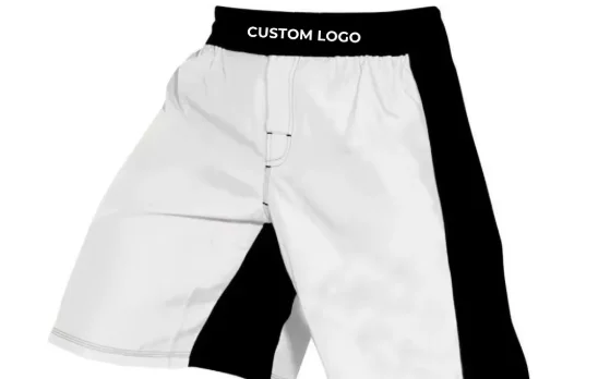 White hybrid MMA shorts with a black elastic waistband, custom logo placement, black side panels, and a drawcord tie