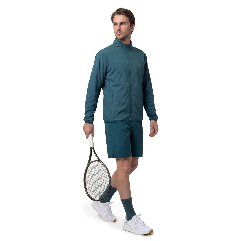 Teal full-zip tennis warm-up jacket with matching shorts, worn on court with a racket and sneakers