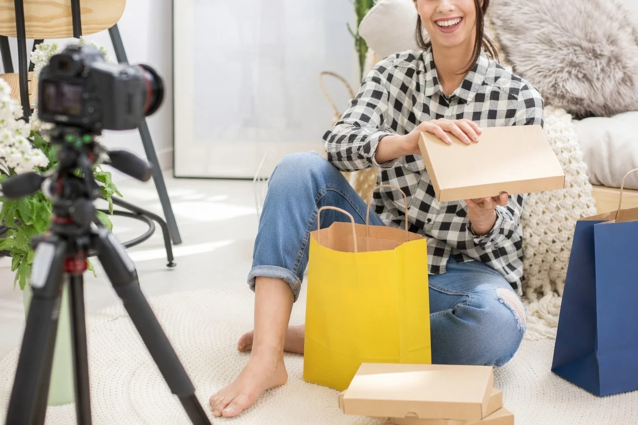 Content creator in a warm, natural-light studio setting — the kind of space where creator merch brands are built